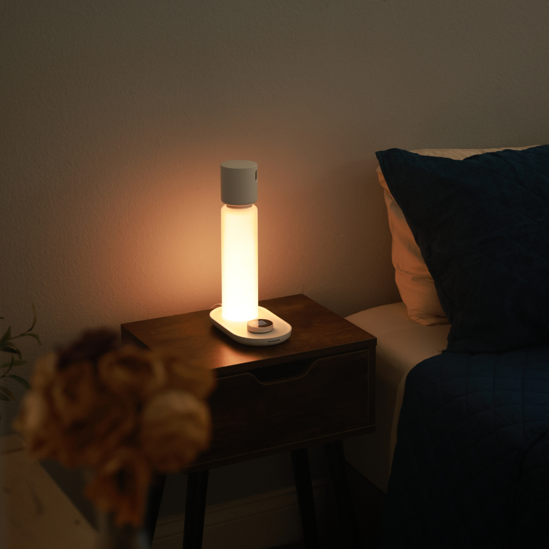 Calm bedroom scene with the Sleepal AI Lamp on a bedside table, showing contactless sleep technology alongside common sleep devices